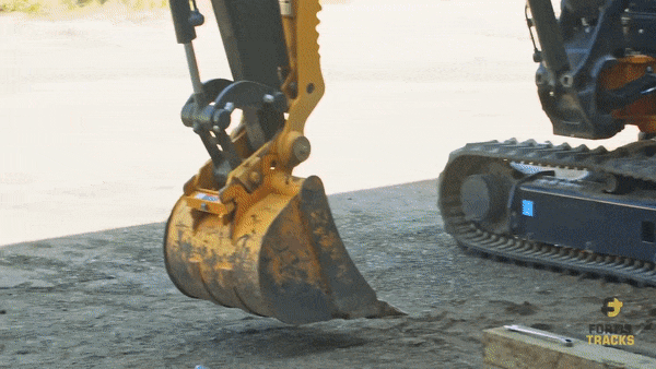 A heavy equipment operator uses the bucket on a mini excavator to lift the machine up on one side