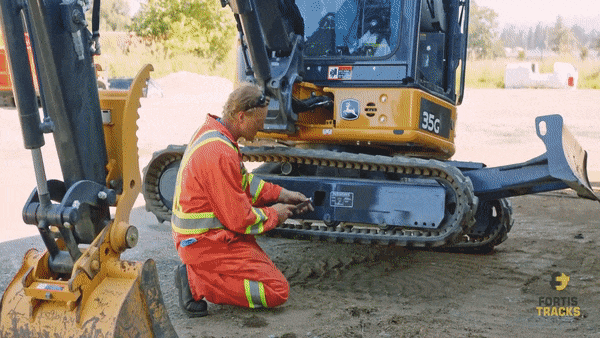 mechanic releasing the track tension on a John Deere 35G excavator