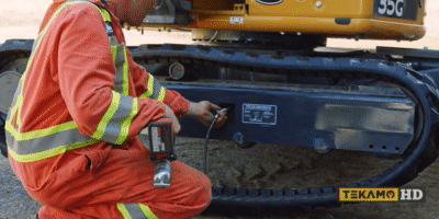 heavy mechanic adjusting the track tension on a John Deere mini excavator