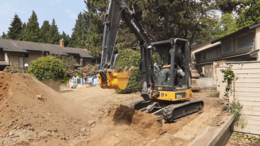 John Deere mini excavator on rubber tracks shifting dirt