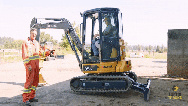 a heavy equipment operator uses the blade and bucket on a mini excavtaor to lift the machine off of its tracks