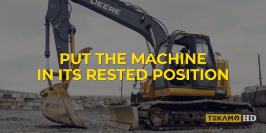 Heavy equipment technician puts a JD excavator into a rest position for parking