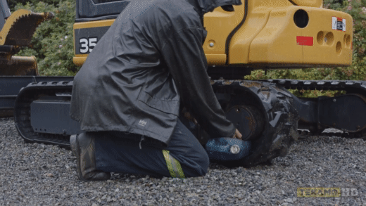Demonstration of final drive bolt removal by a heavy mechanic
