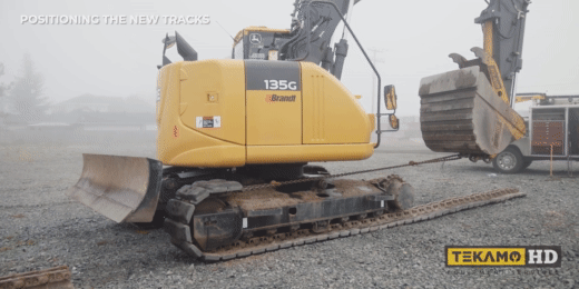 Demonstrating how to use the excavator bucket and a chain to replace the track on an excavator