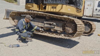Heavy duty mechanic shows how to check track tension on mini excavator