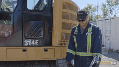 Heavy equipment technician compares an old and new air filter