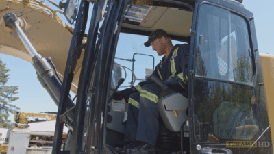 Heavy equipment mechanic turns the excavator engine