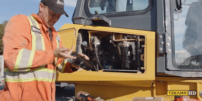 Gif of a pro-mechanic installing the first new hydraulic filter on a John Deere dozer