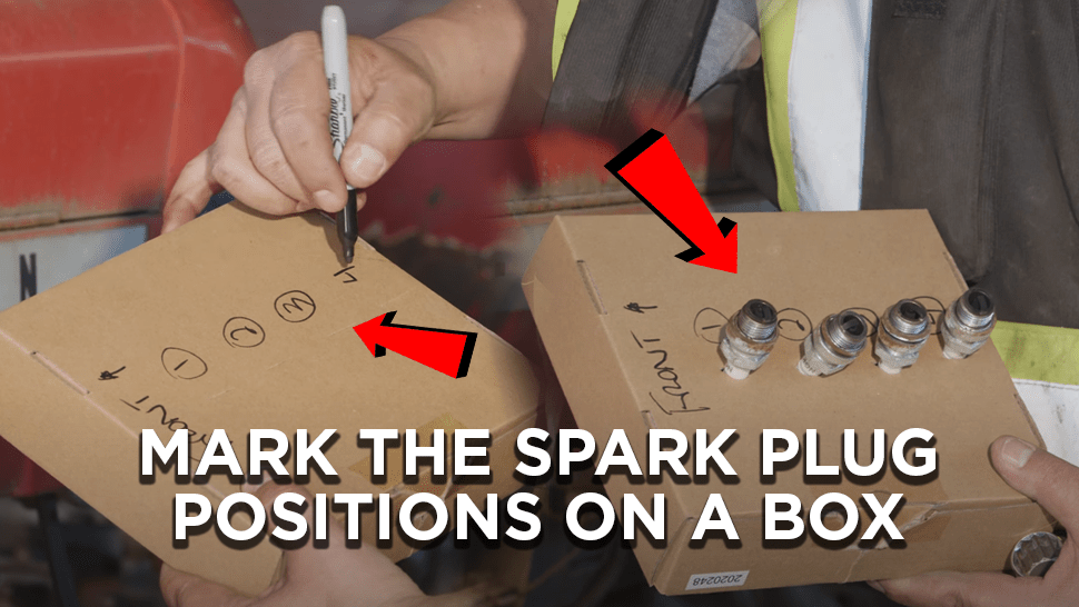 Mechanic marking the spark plug positions on a box